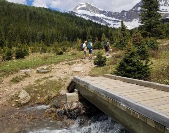 Hikers pause after crossing footbridge on epic hike in Lake Louise