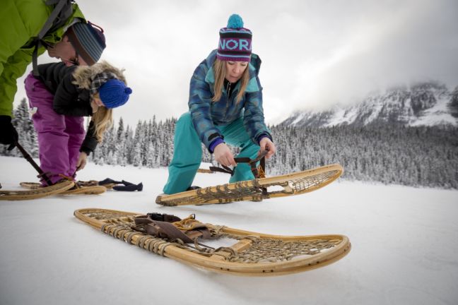 putting on wooden snowshoes with White Mountain Adventures