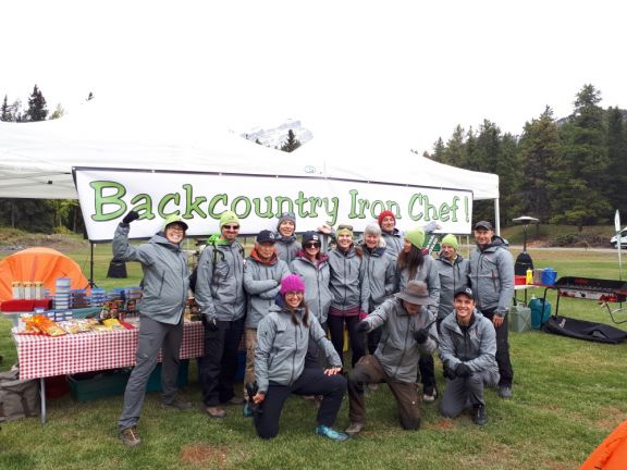 Staff posing in front of Backcountry Iron Chef Banner